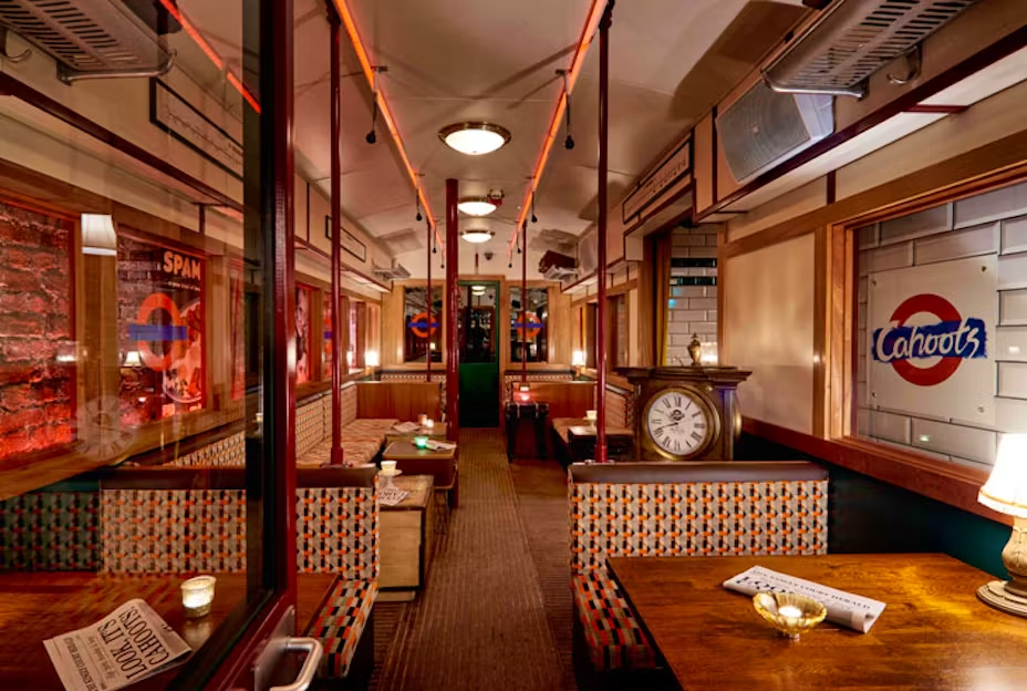 Interior view of a train car featuring tables and chairs arranged for passenger seating and comfort